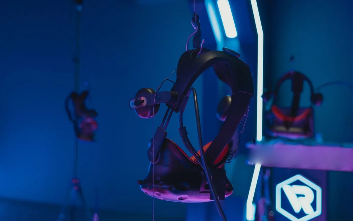 VR headsets displayed in a dark neon-lit gaming space